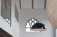 Pendant light in front of old church window 