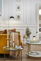 Lit candles on vintage side table in modern living room at Christmas 