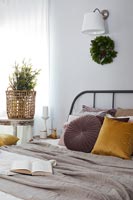 Modern country bedroom with Christmas wreath on wall 