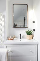 Mirror over chest of drawers in modern bathroom 