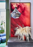 Decorative chandelier in front of large red painting 