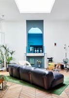 Modern living room with angled leather sofa in centre 