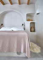 Country bedroom with moulded arch alcove at head of bed 