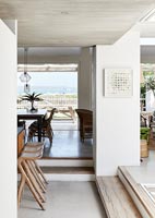 Modern dining room with view through patio doors to sea beyond 