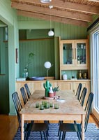 Country dining room with green painted walls and exposed wooden beams 