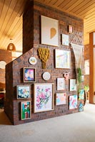 Exposed brick wall covered in framed pictures