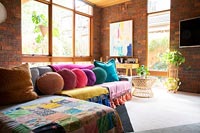 Modern living room with colourful cushions on corner sofa 
