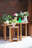 Nest of wooden tables with potted houseplants 