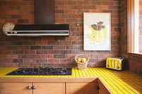 Yellow tiling on worktop of modern kitchen 