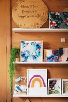 Paintings and pictures in frames on shelves in childrens room  