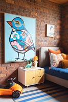 Large colourful painting on exposed brickwork wall in childrens bedroom 