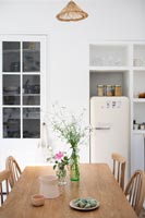Wooden table and chairs in white country kitchen-diner