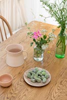 Fresh almonds on wooden dining table with wild flower arrangements 