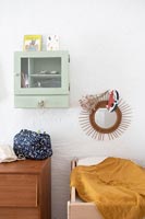 Wall mounted shelf unit on white wall in childrens room 