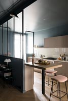 Modern kitchen with dark grey painted walls and pale pink cabinets 