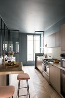 Modern kitchen with dark grey walls and parquet flooring 