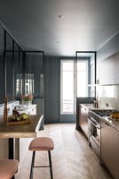 Modern kitchen with dark grey painted walls and parquet floors 
