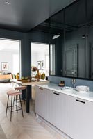 Modern kitchen with dark grey painted walls and parquet flooring 