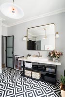 Large mirror over sink in bathroom with monochrome floor
