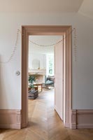 View into living room through doorway - woodwork painted dusky pink 