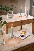 Candles on wooden tables with drink and Christmas biscuits 