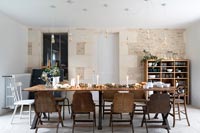 Country dining room with exposed stone feature wall and wooden table 