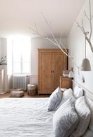 White painted wall mounted branches as bedroom Christmas decorations 