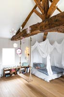 Swing suspended in childrens bedroom with vaulted ceiling 