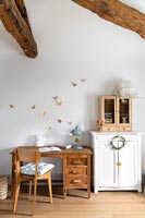 Desk and chair in childrens room with exposed wooden beams 