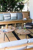 Wooden furniture and cushions in outdoor living room area 