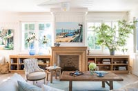 Nautical painting above wooden fireplace in country living room 