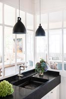 Black and white sink with pendant lights and view through internal windows 