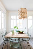 Country dining room with green vintage chairs 