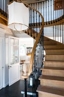 Wooden staircase with black railings and modern lampshade 