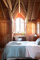 Country bedroom with wooden vaulted ceilings and dressing table 
