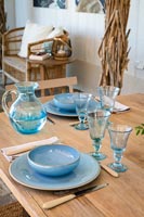 Blue crockery and glassware on outdoor dining table 