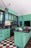 Red black and white checkerboard flooring in mint green modern kitchen 