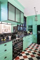 Bright mint green kitchen with black, red and white checkerboard floor 