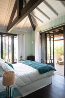 Country bedroom with open French windows to terrace 