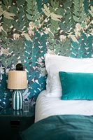 Detail of floral wallpaper behind bed 