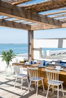 Outdoor dining area on decking overlooking the sea