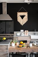 Macrame wall hanging in modern black and white kitchen 