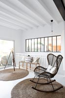 Modern wicker rocking chair in white living room 