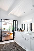 Monochrome modern kitchen with view to outdoor dining area 