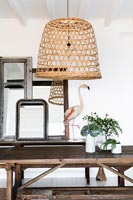 Wicker lampshade and flamingo ornament in white and wood dining room 