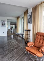 Grey parquet style flooring in retro living room 