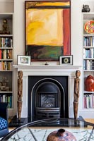 Colourful artwork over fireplace 