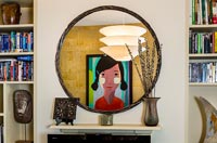Reflection of colourful painting in round mirror 