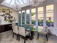 Modern dining room in glazed extension with view to patio 