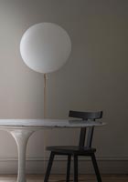 White balloon lamp next to table and chair 